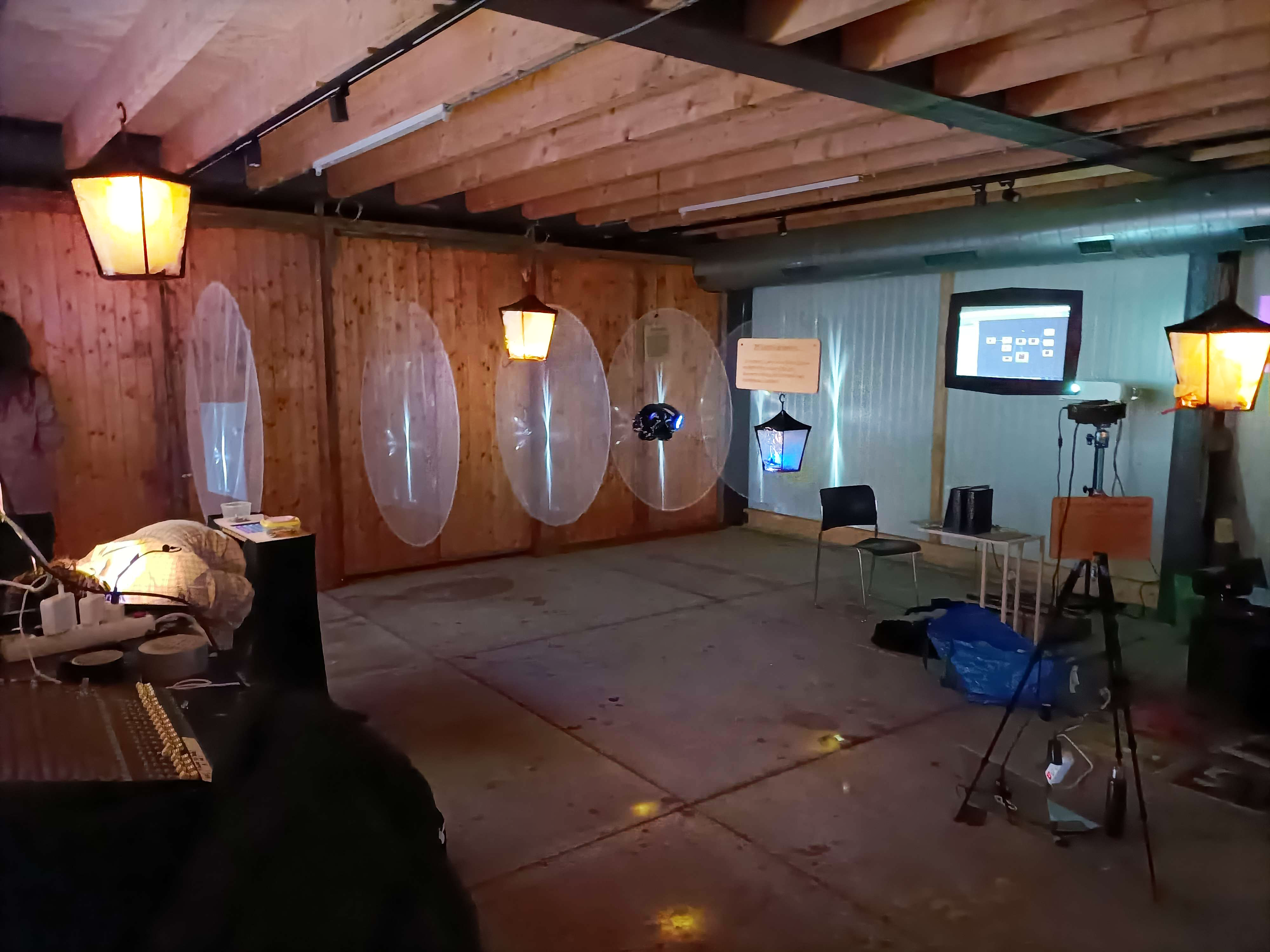 Multiple lanterns float in a room